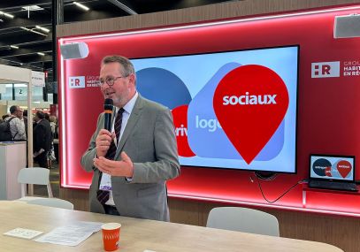 Yves-Marie Hervé, DG d'éligéo, présente éligéo, micro à la main, dans le stand de la Caisse d'épargne lors du Congrès Hlm 2026