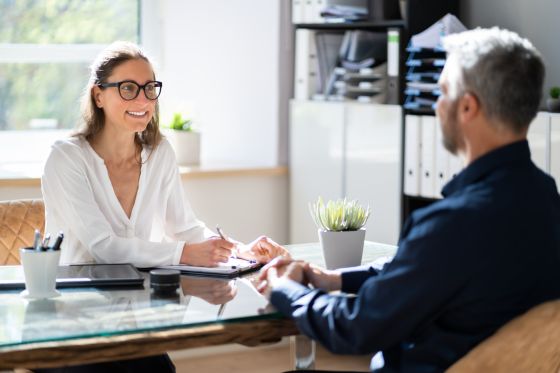 Entretien en bureau entre deux personnes autour d’une table de travail.
