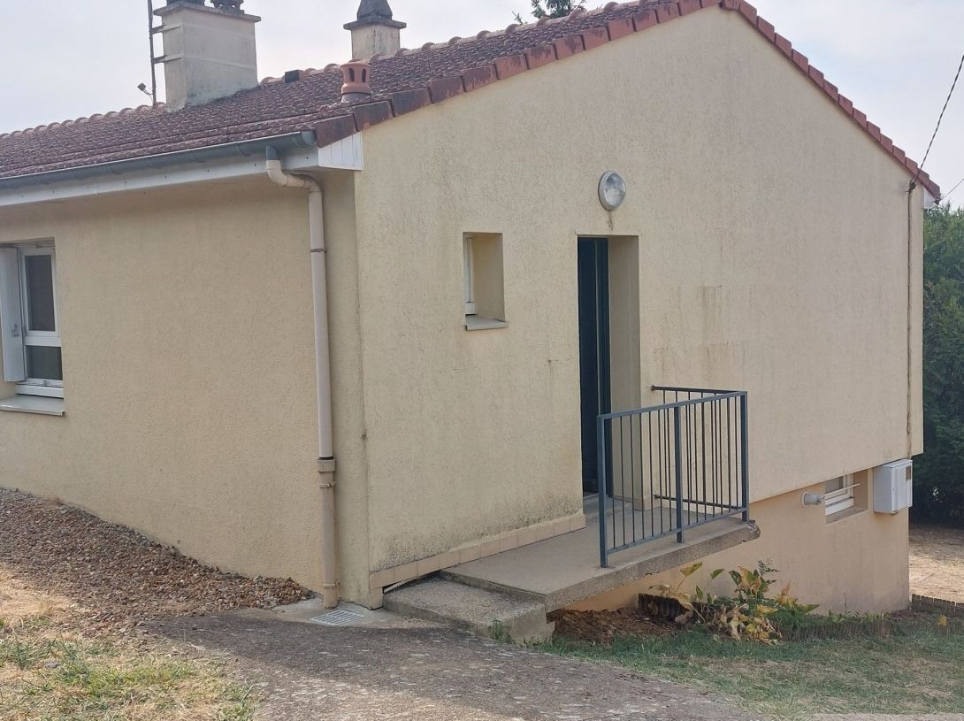 Maison de plain-pied avec jardin et garage.
